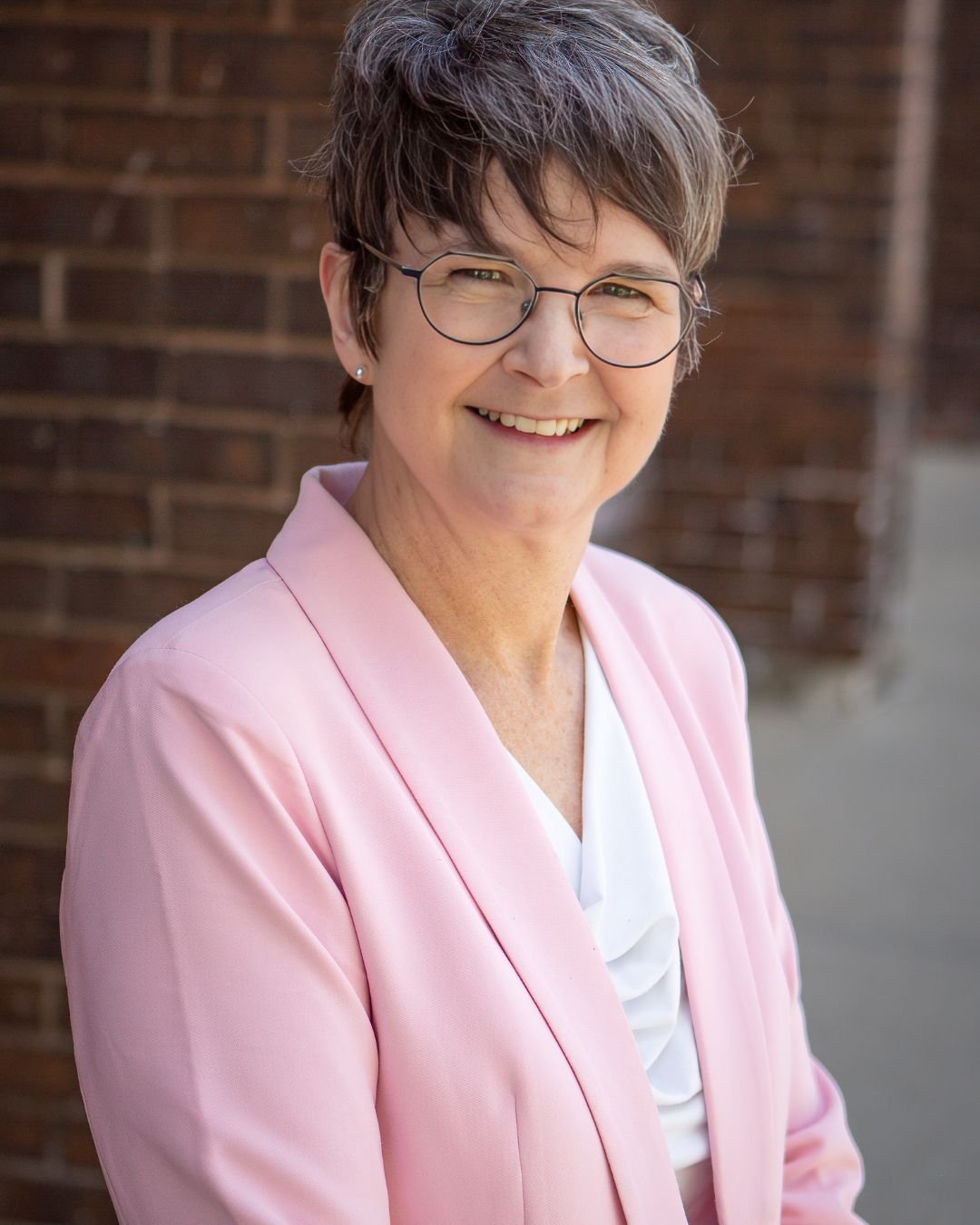 Karen LaHay in front of a brick wall.