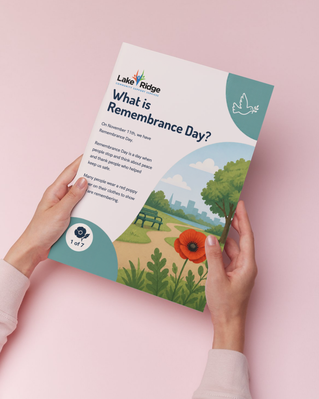 Image of woman's hands holding the Remembrance Day Social Narrative showing the cover with an image of a poppy in a park and the words What is Remembrance Day. Links to the download.