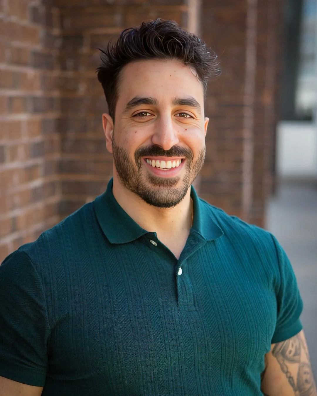 Davidy Maidany in front of a brick wall.