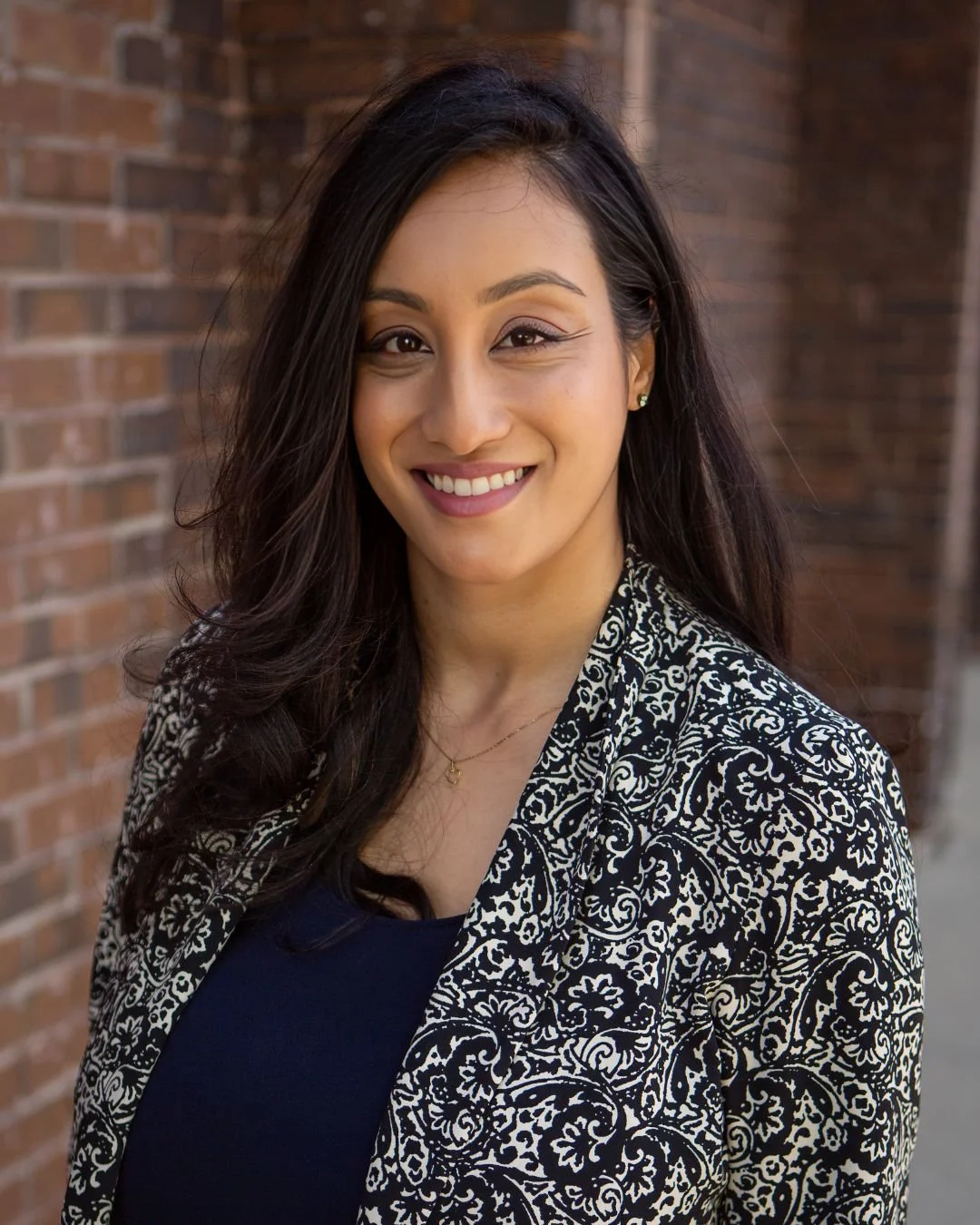 Tarisha Singh in front of a brick wall.