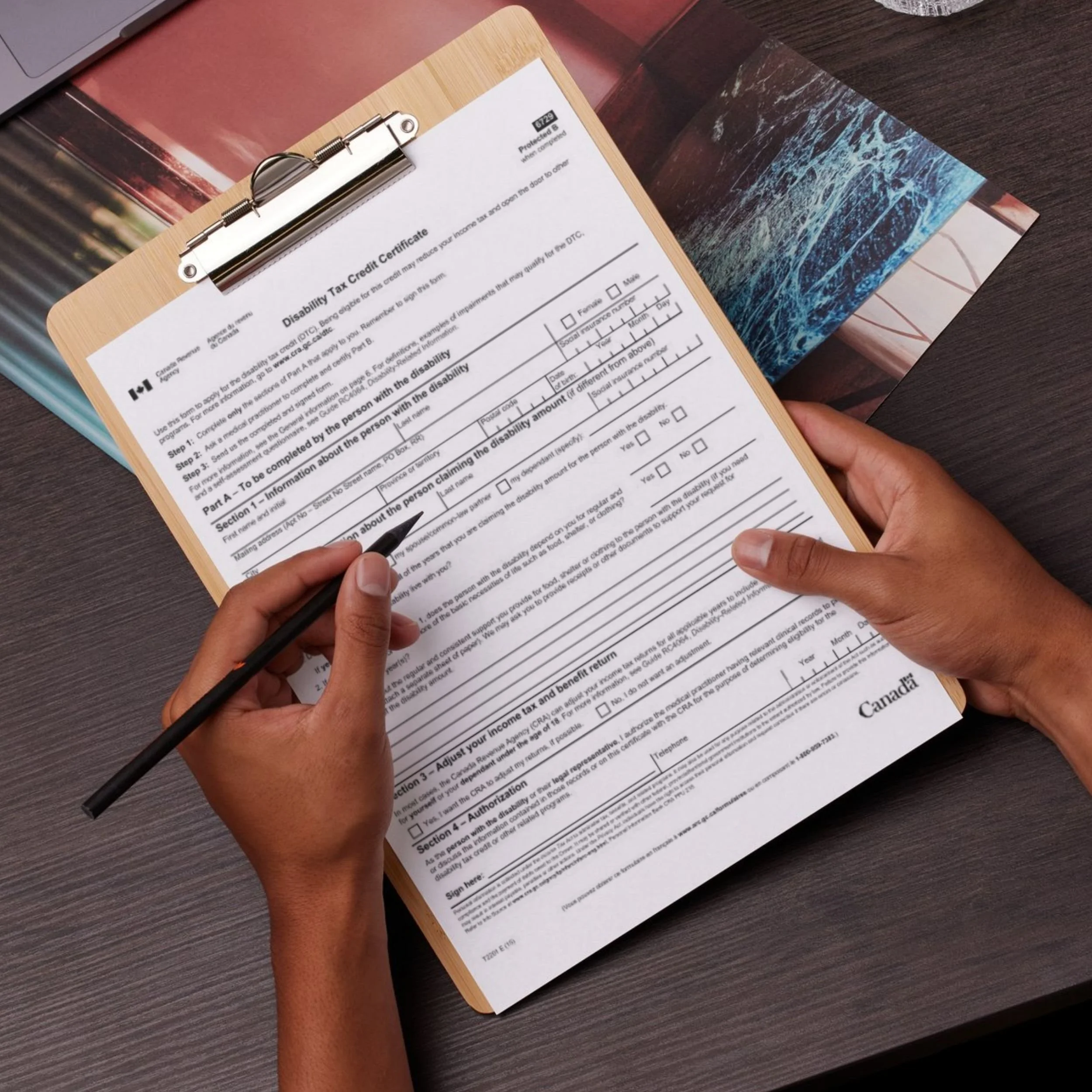 Woman filling out the DTC form T2201 with her pen.