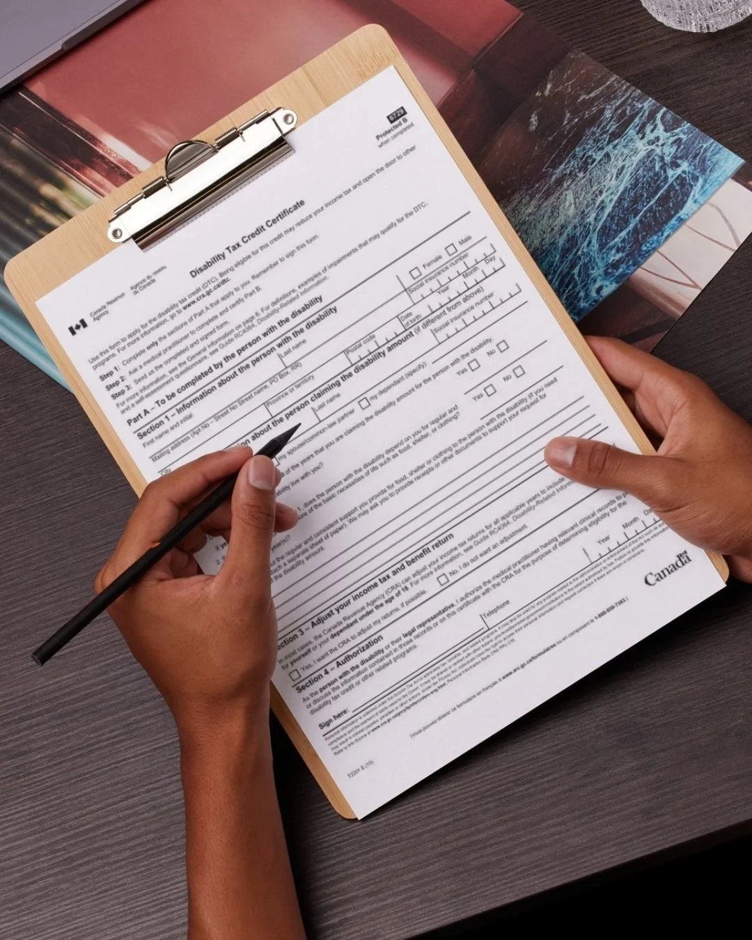 Image of hand holding a pen about to fill our the T2201 Form.