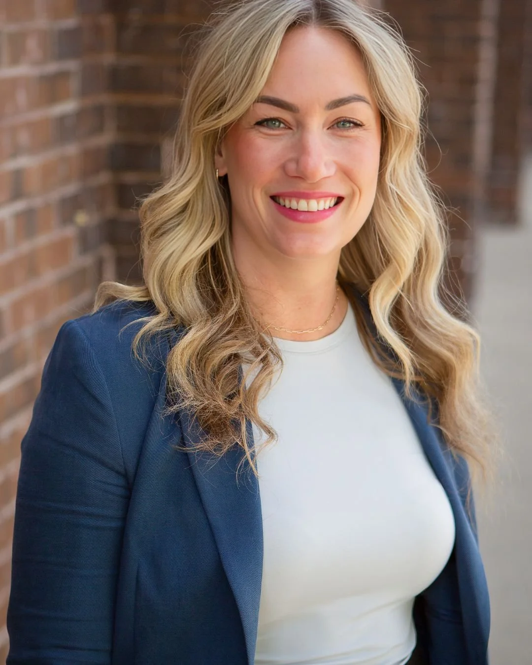 Katey Danaher in front of a brick wall.