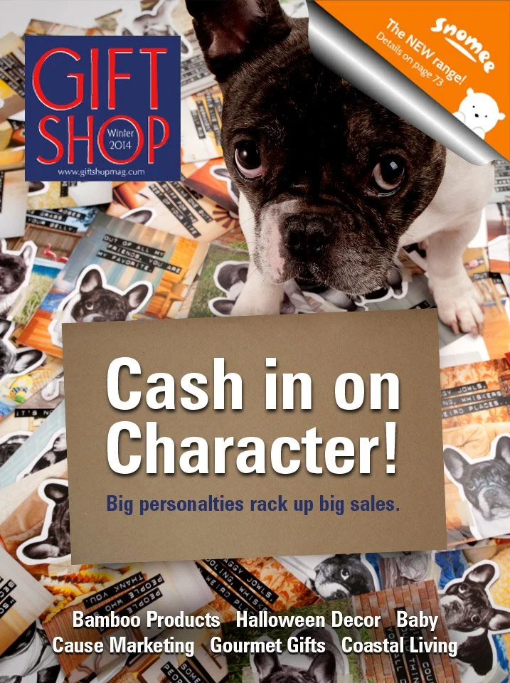 Cover of Gift Shop magazine, Winter 2014 issue, featuring a French Bulldog puppy. The headline reads 'Cash in on Character! Big personalities rack up big sales.' The background is filled with various dog stickers, cards, and promotional materials.