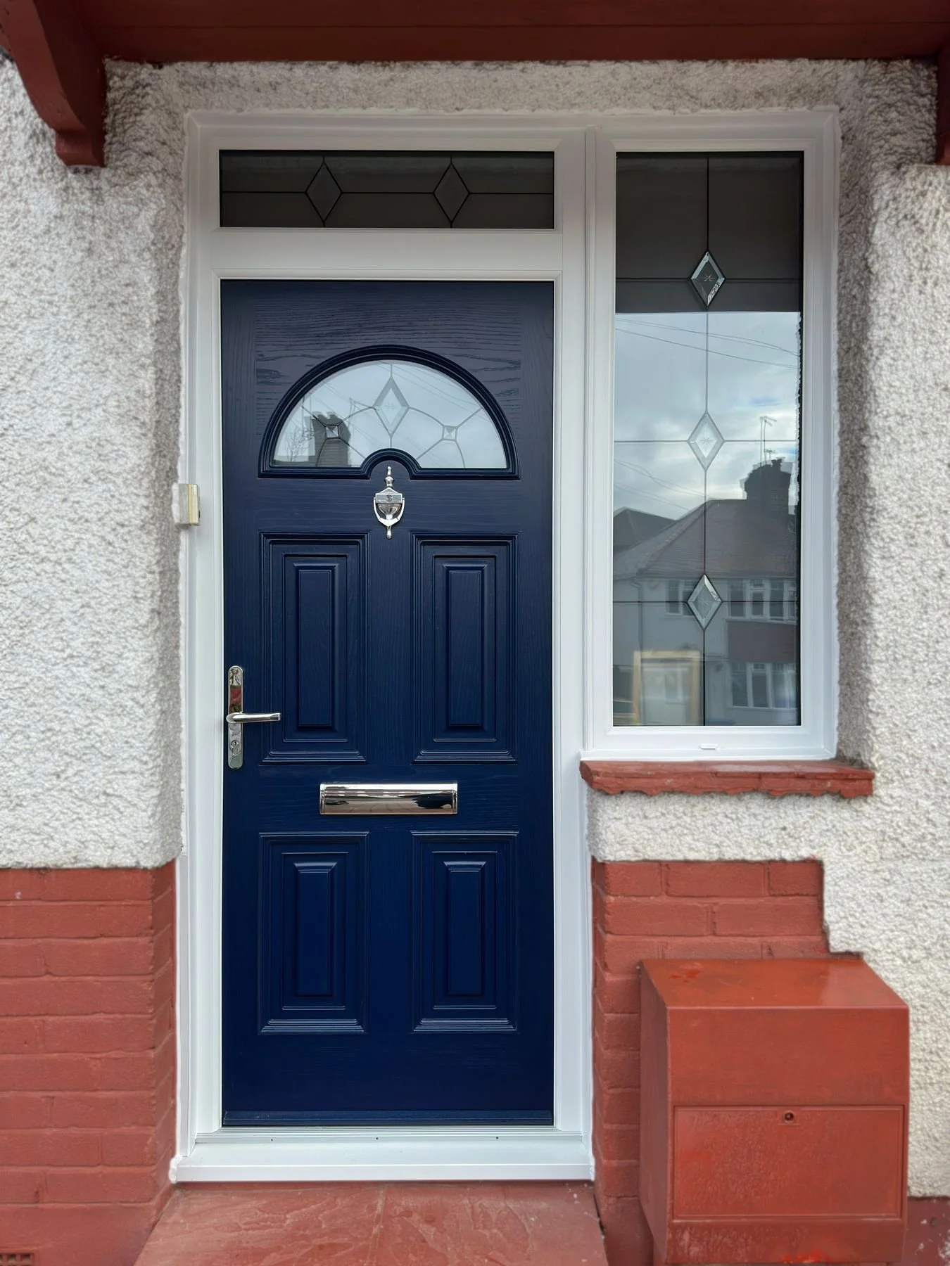 Navy blue composite front door with glazed side panels, installed by Oakwood Windows in North London