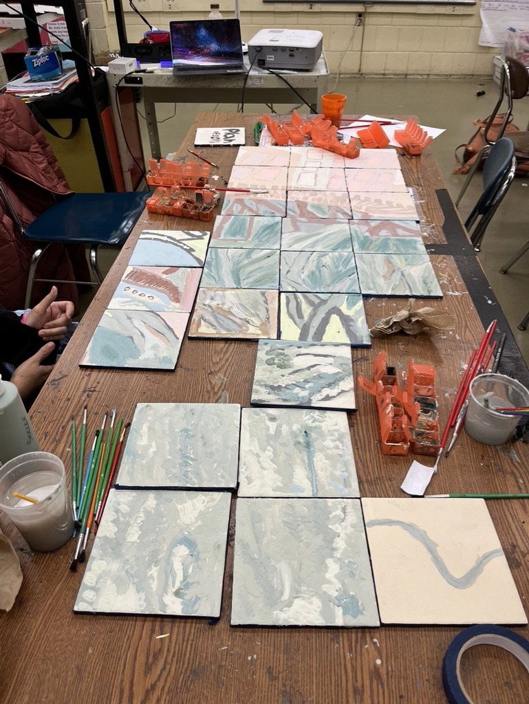 Unfired tiles process table from paint night.jpeg