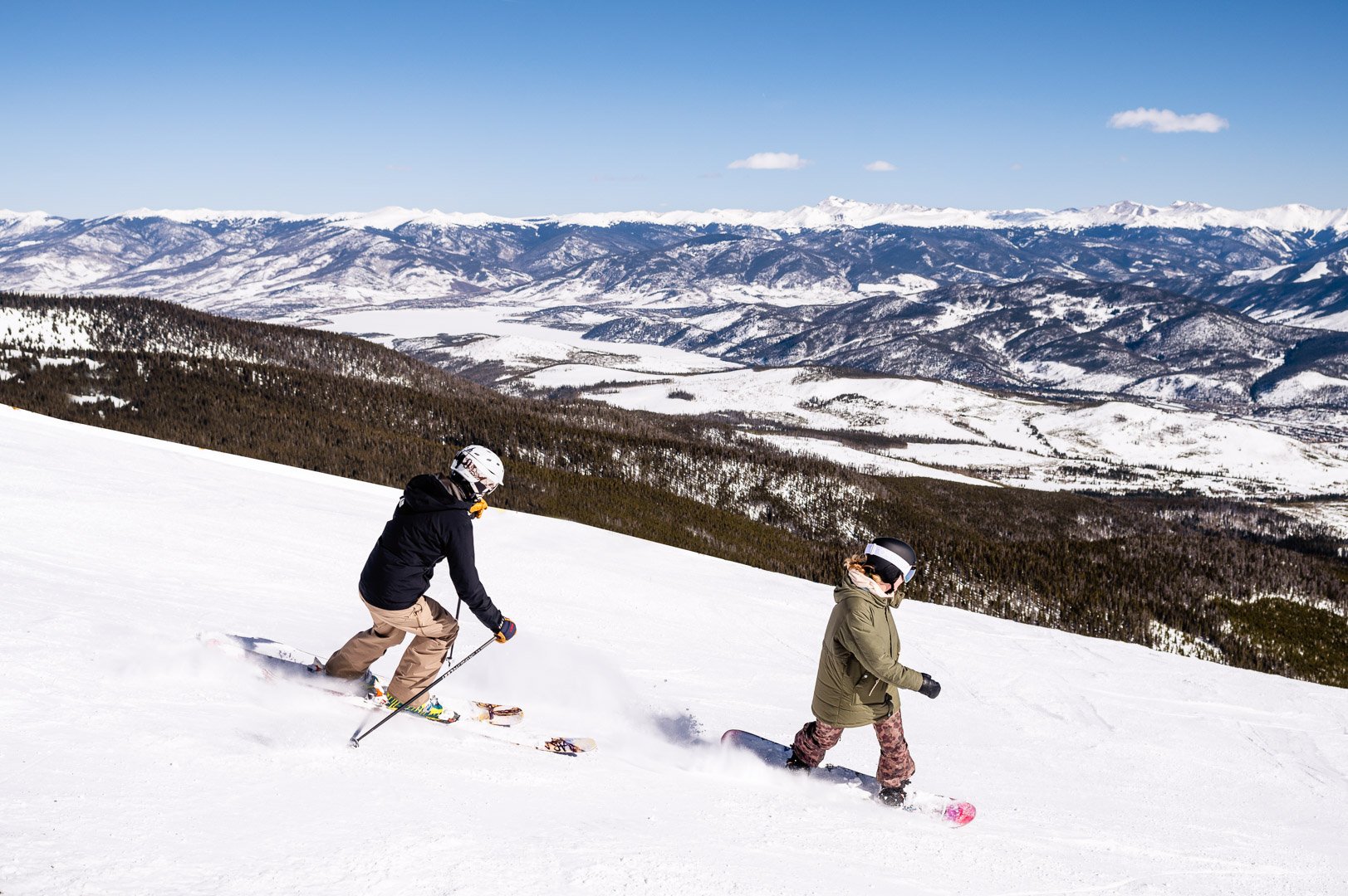 Engaged couple skiing and snowboarding at Breckenridge, Colorado after getting engaged on the mountain