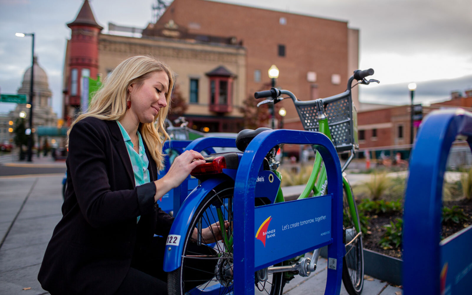 Woman unlocking Boise GreenBike downtown