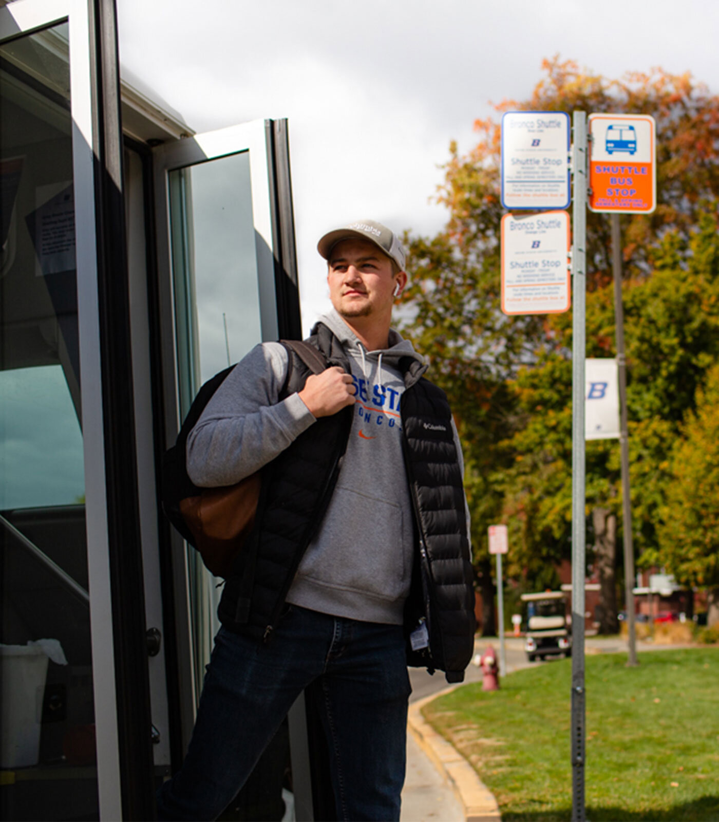Boise State student getting off Bronco shuttle at a Boise bus stop