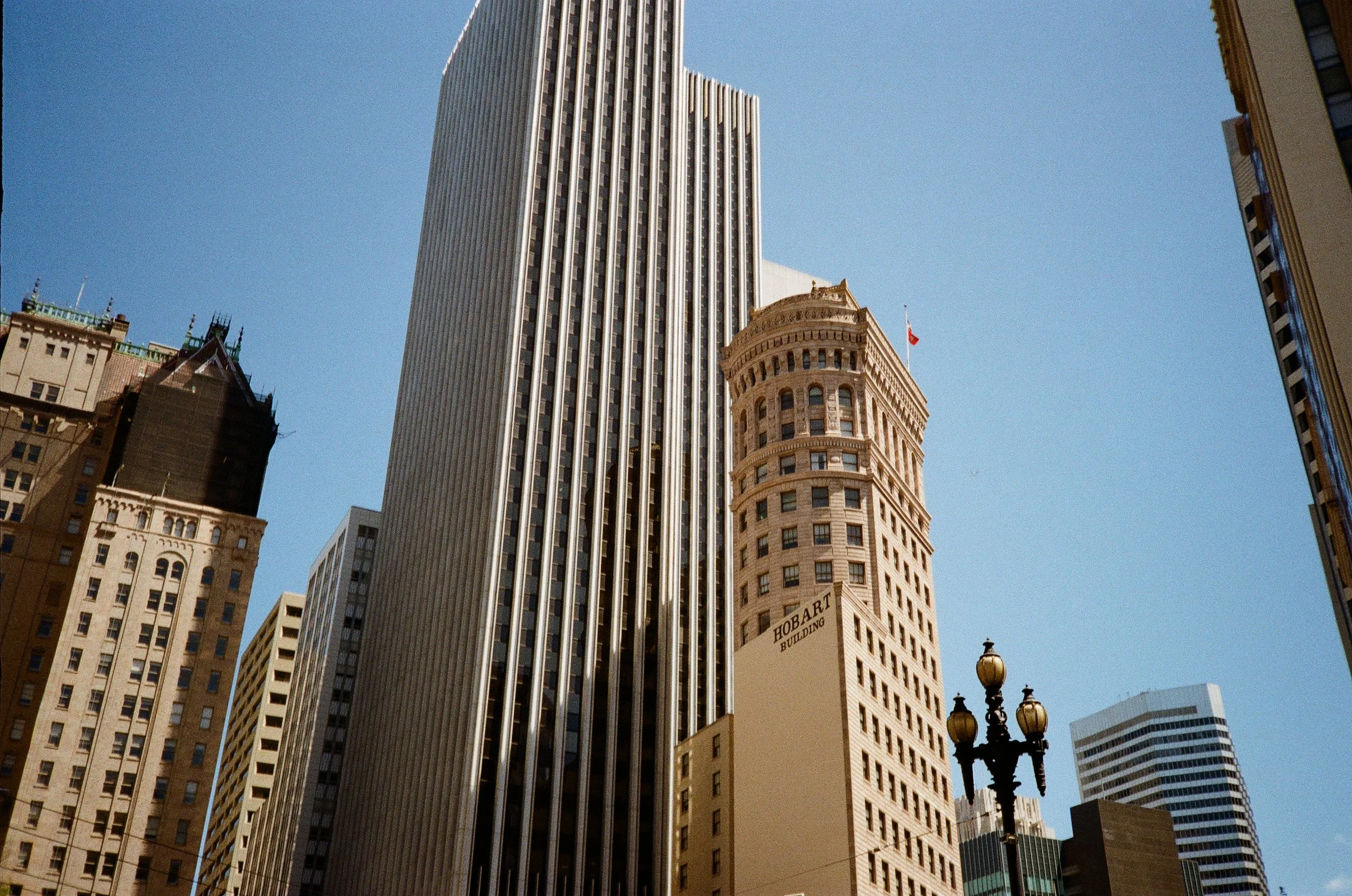 Tall skyscrapers in an urban cityscape with a clear blue sky background.