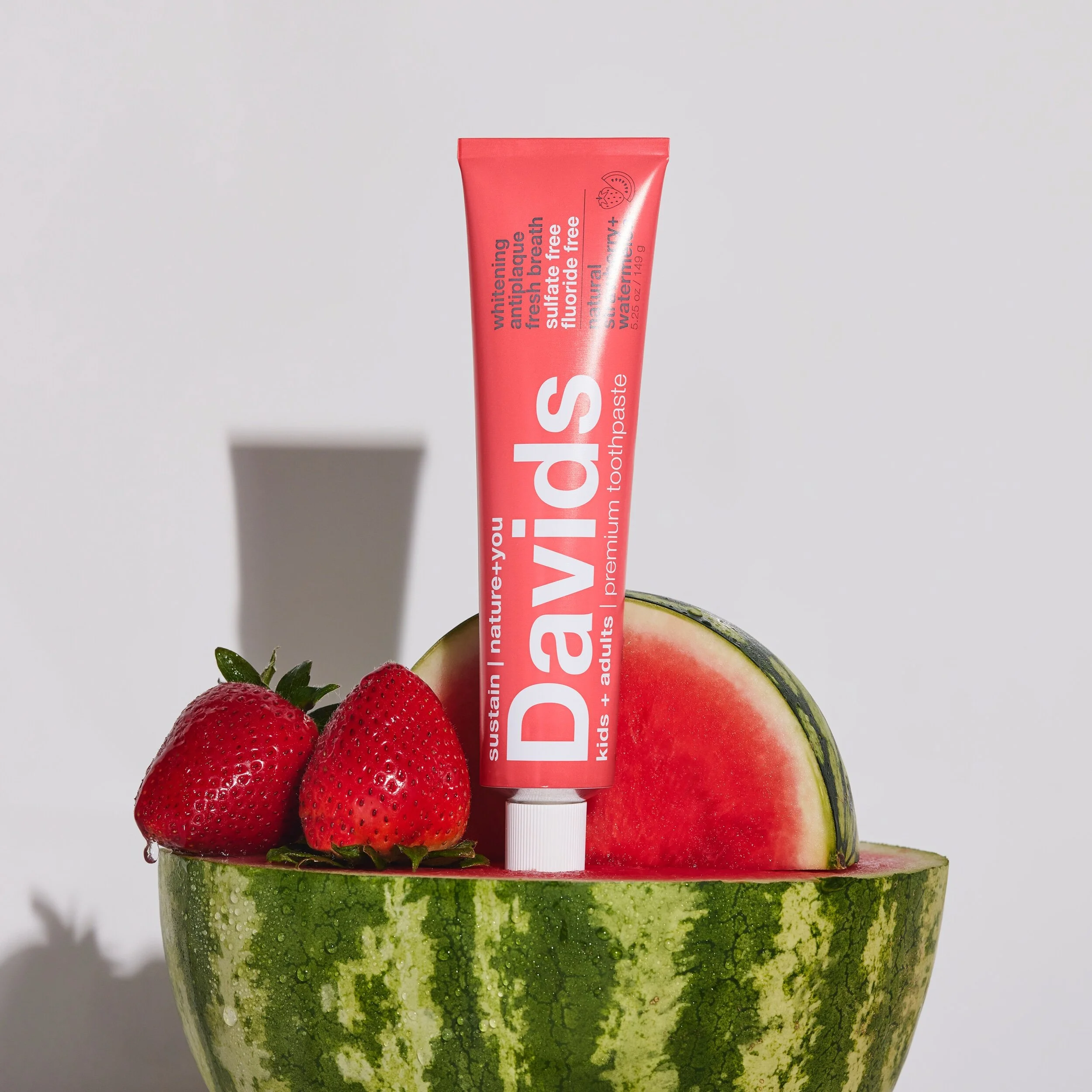 David's Natural Toothpaste nestled inside a vibrant watermelon, showcasing a fresh and fruity dental care option.