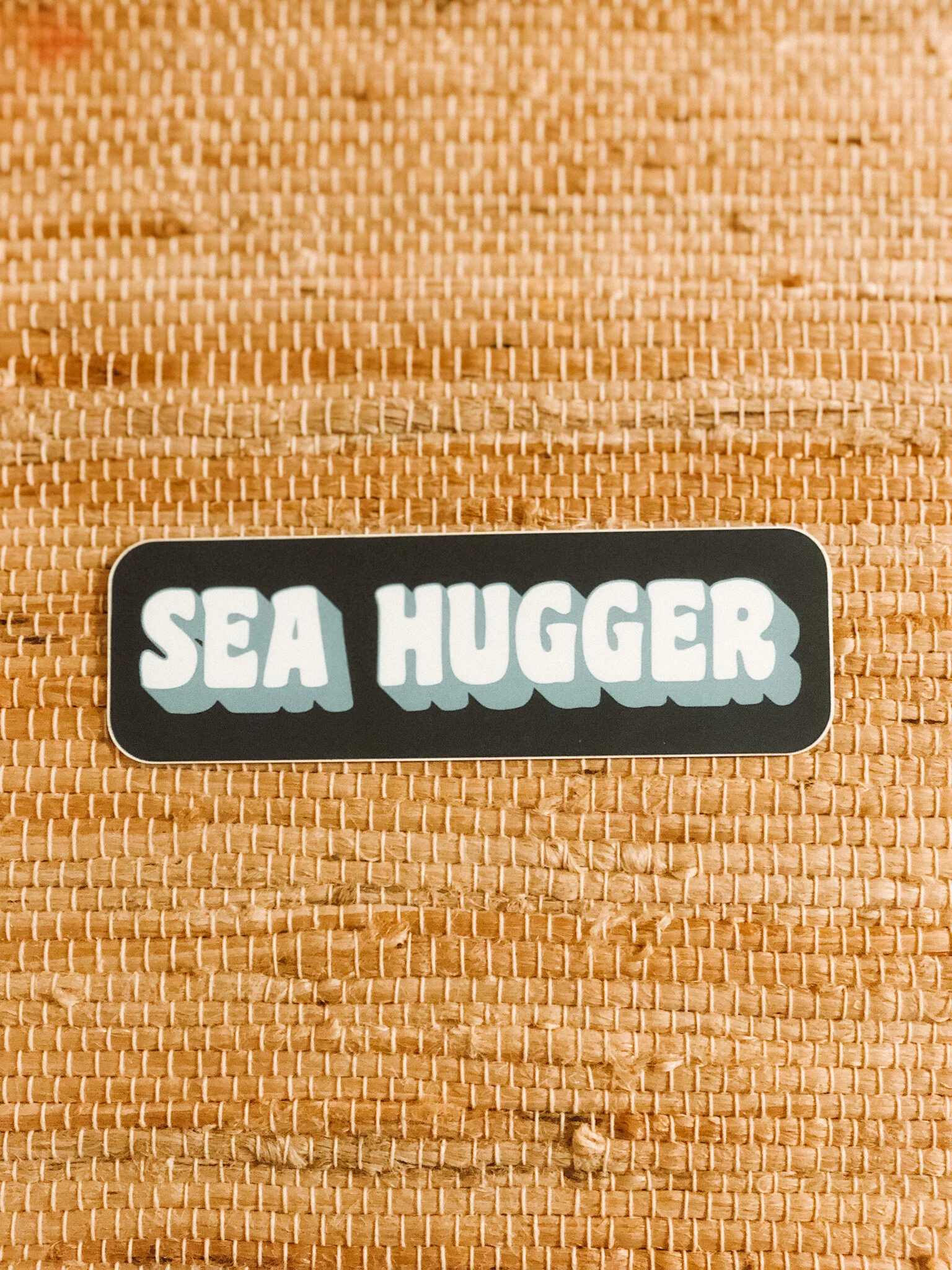 A colorful bumper sticker featuring the phrase "Sea Hugger" with ocean-themed graphics, promoting marine conservation.