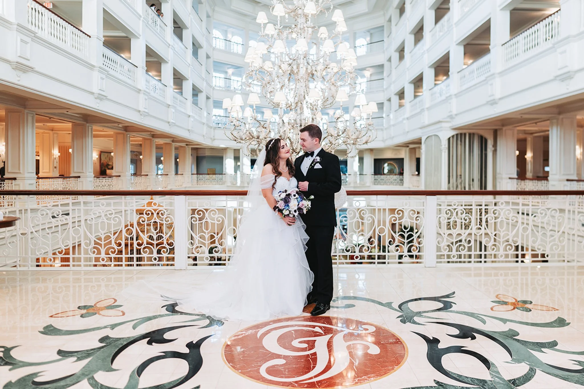 Grand Floridian lobby wedding portraits with chandeliers and Victorian architecture.