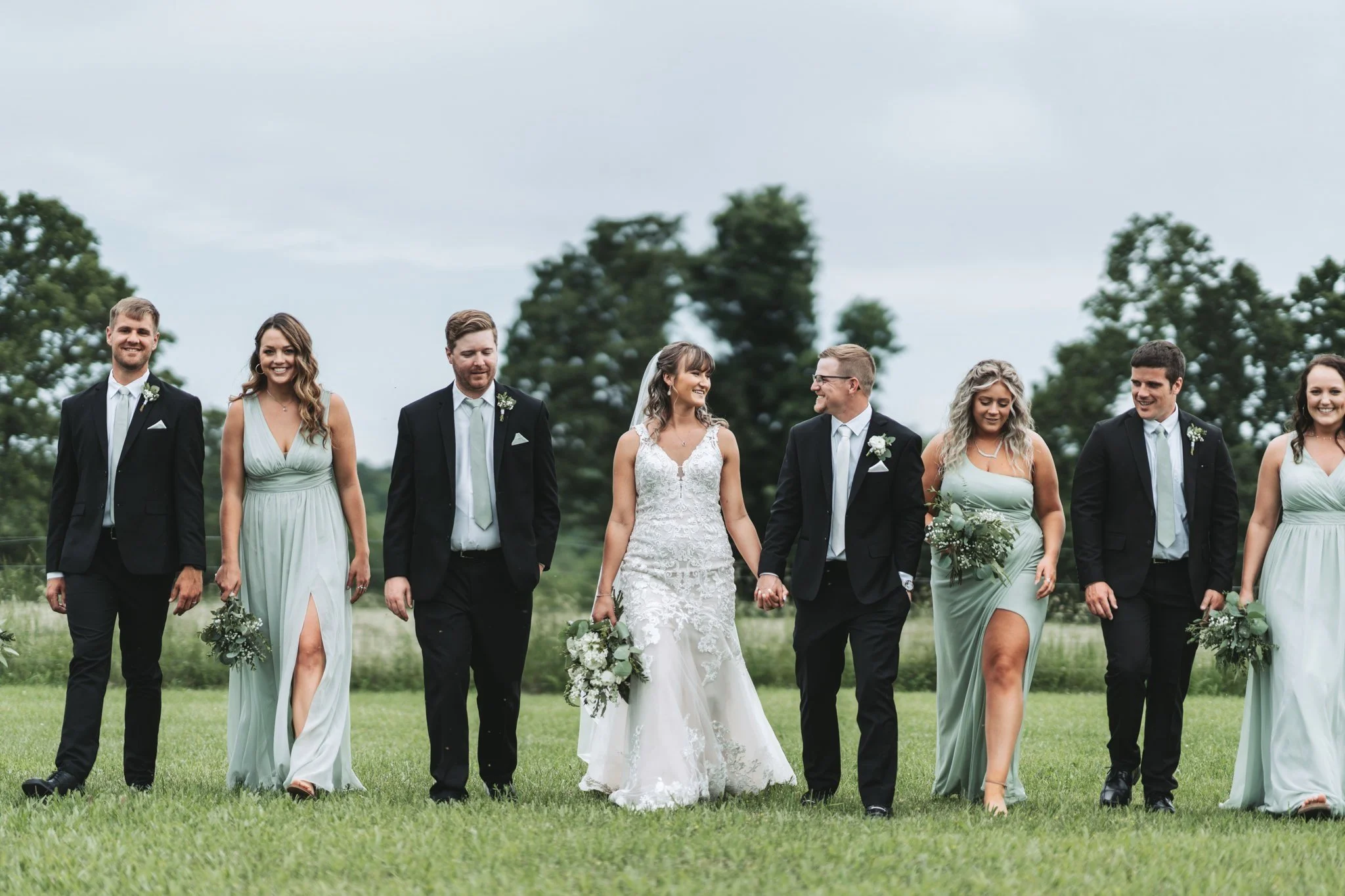Rustic summer Missouri wedding bridal party candid walking photo in natural outdoor setting