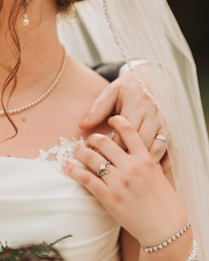 Couple holding hands close up on wedding rings.