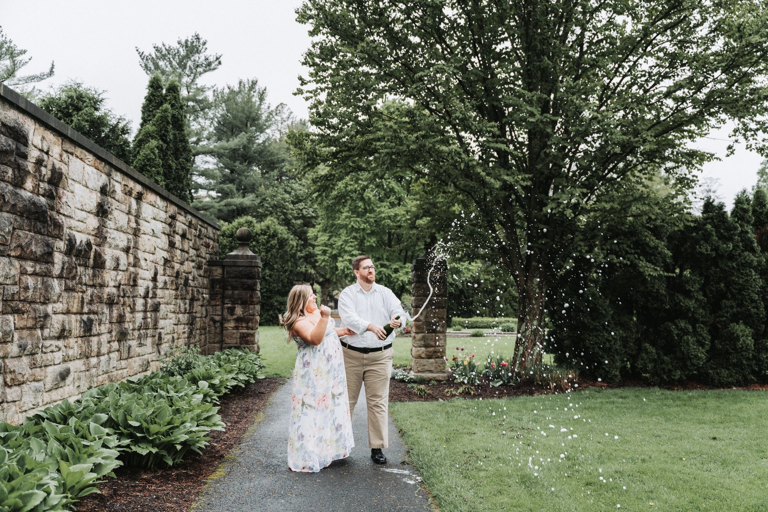 engagement-session-popping-champagne-bottle-prop-mount-assissi-gardens-loretto-pa.jpg