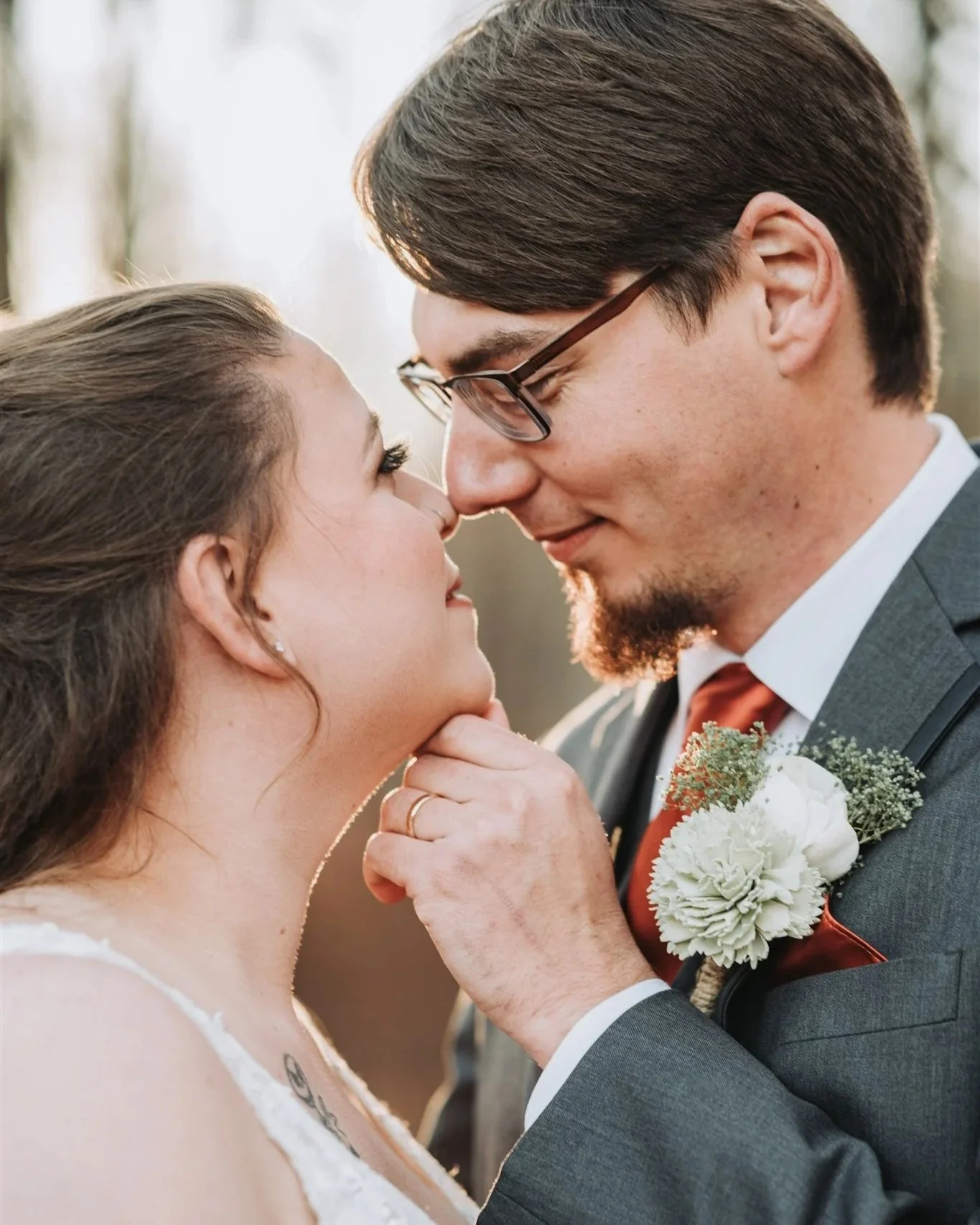 Couple portrait where groom gently touches brides chin.