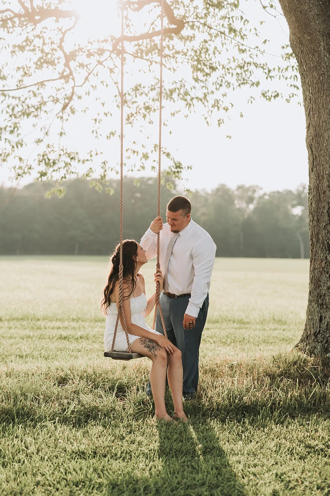 Golden hour swing portraits during Tuck'd Inn Farm wedding reception in summer.
