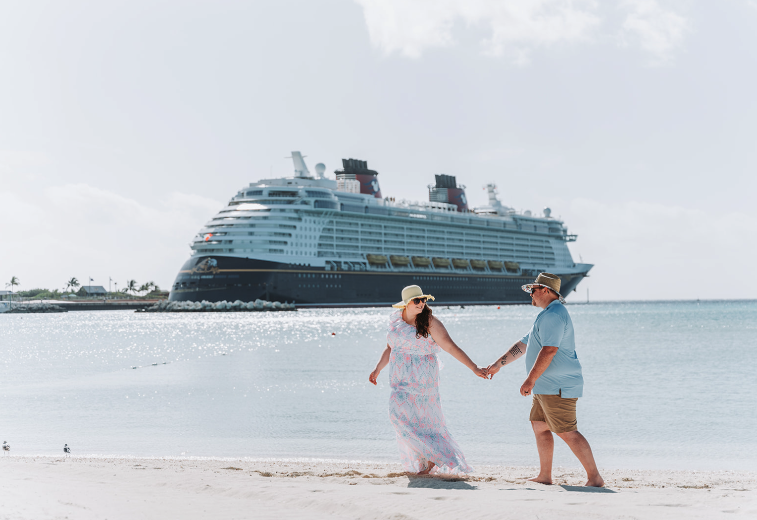 Couple walking along the beach during a Disney Castaway Cay engagement photo session.
