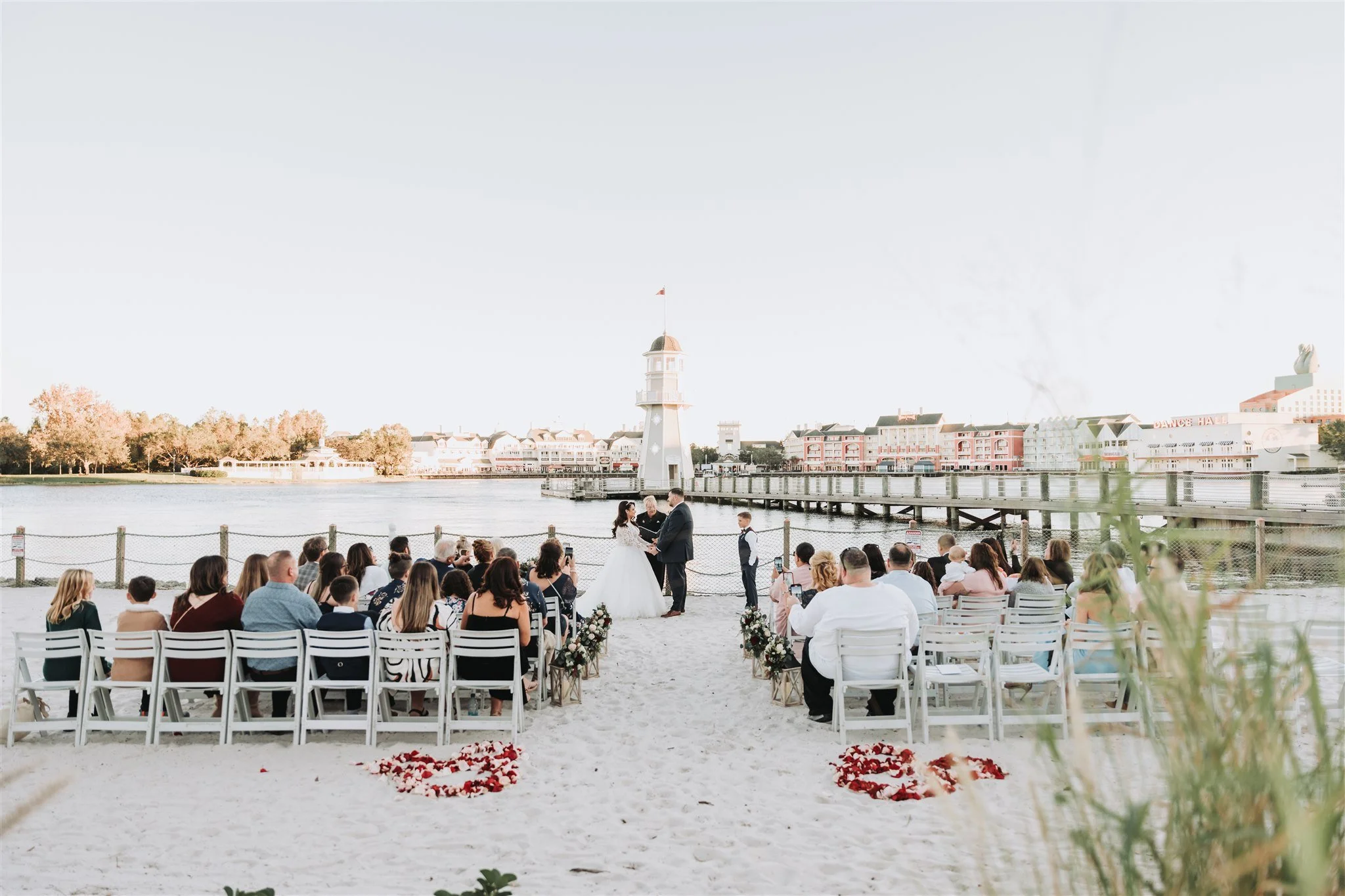 Beach ceremony at Crescent Cove Disney's Yacht Club Resort with Crescent Lake backdrop.