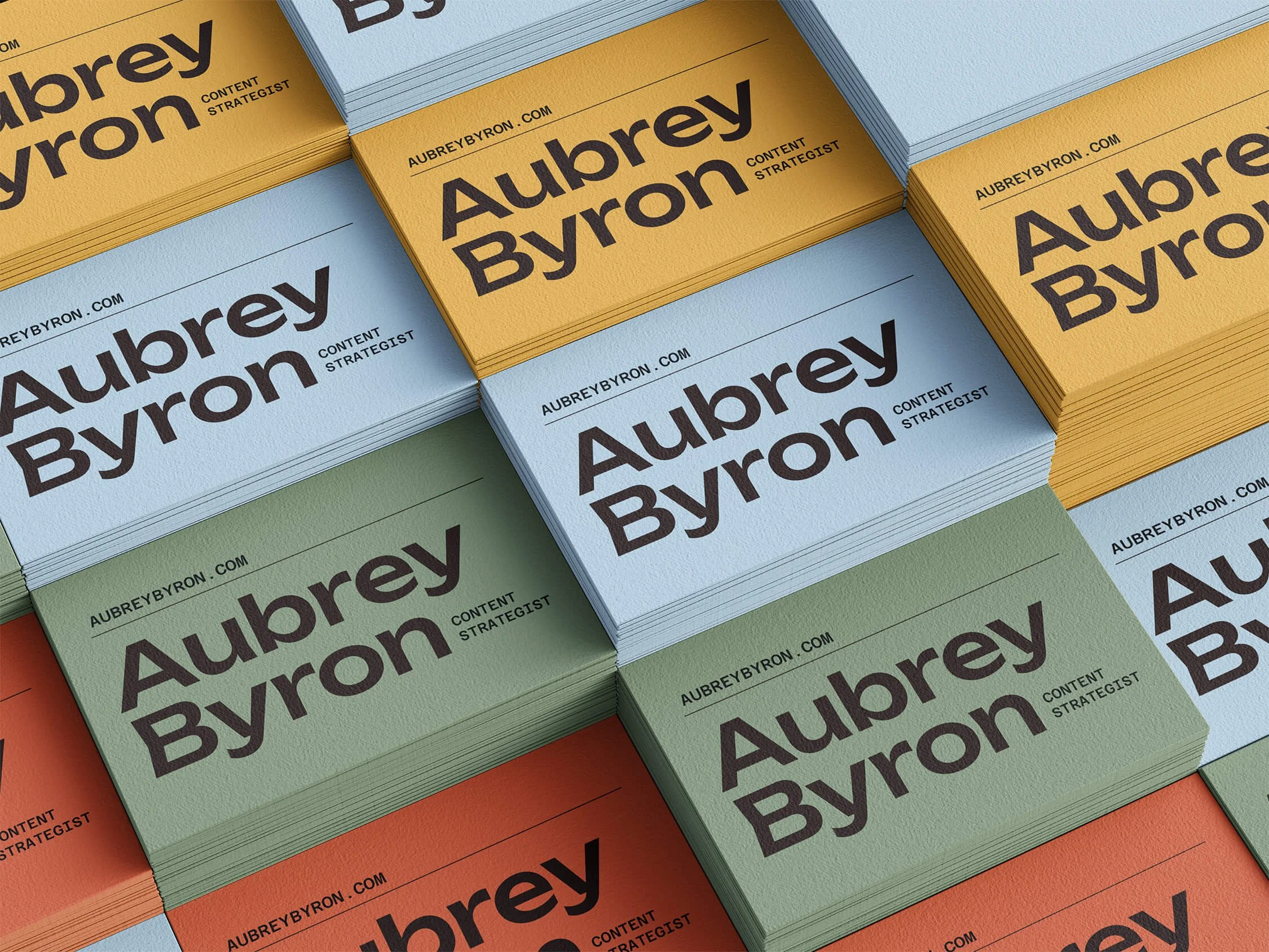 Stacks of business cards at varying heights show Aubrey Byron's logo and website