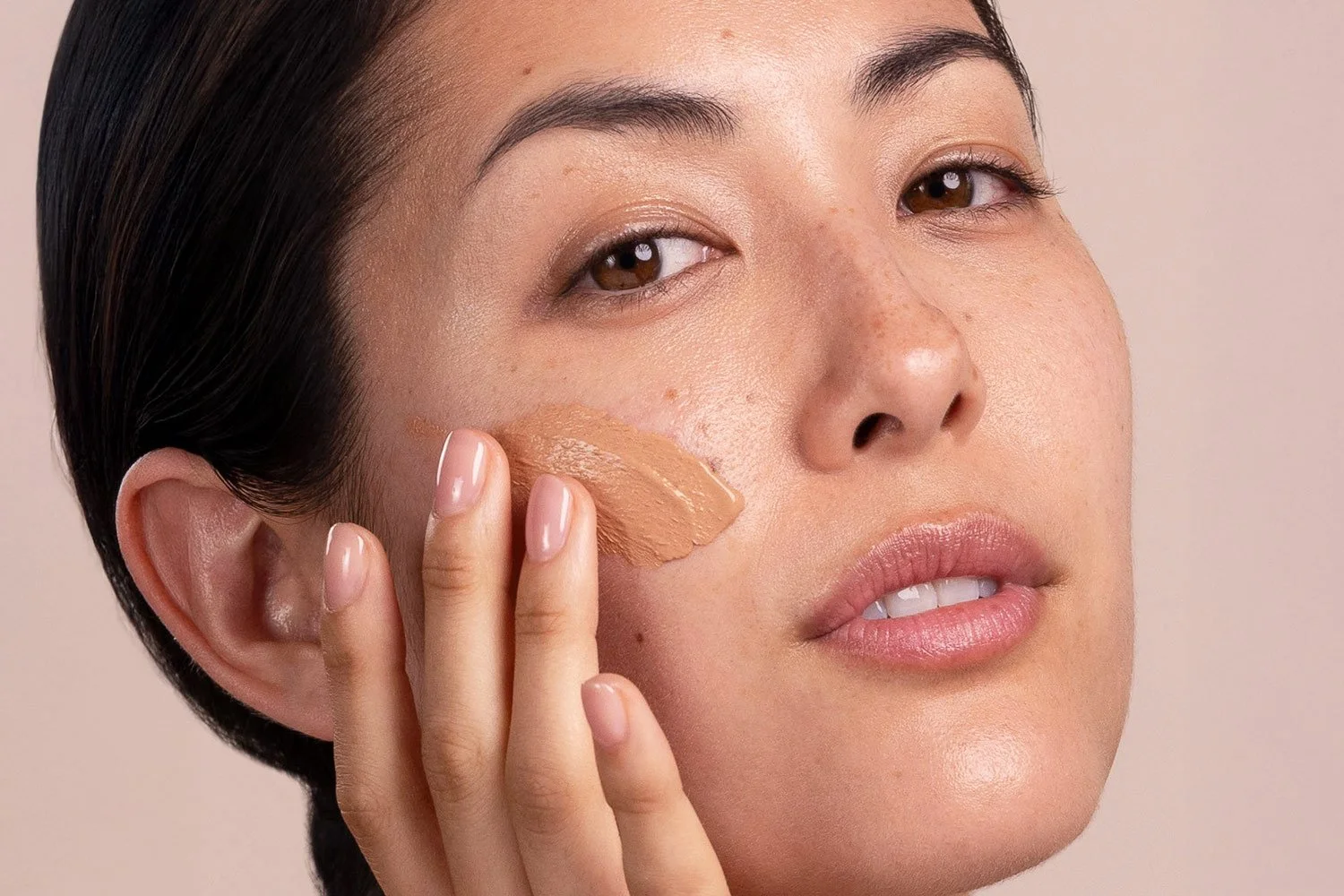 A woman applying Eminence Organics Acne Advanced Clarifying Masque on her face