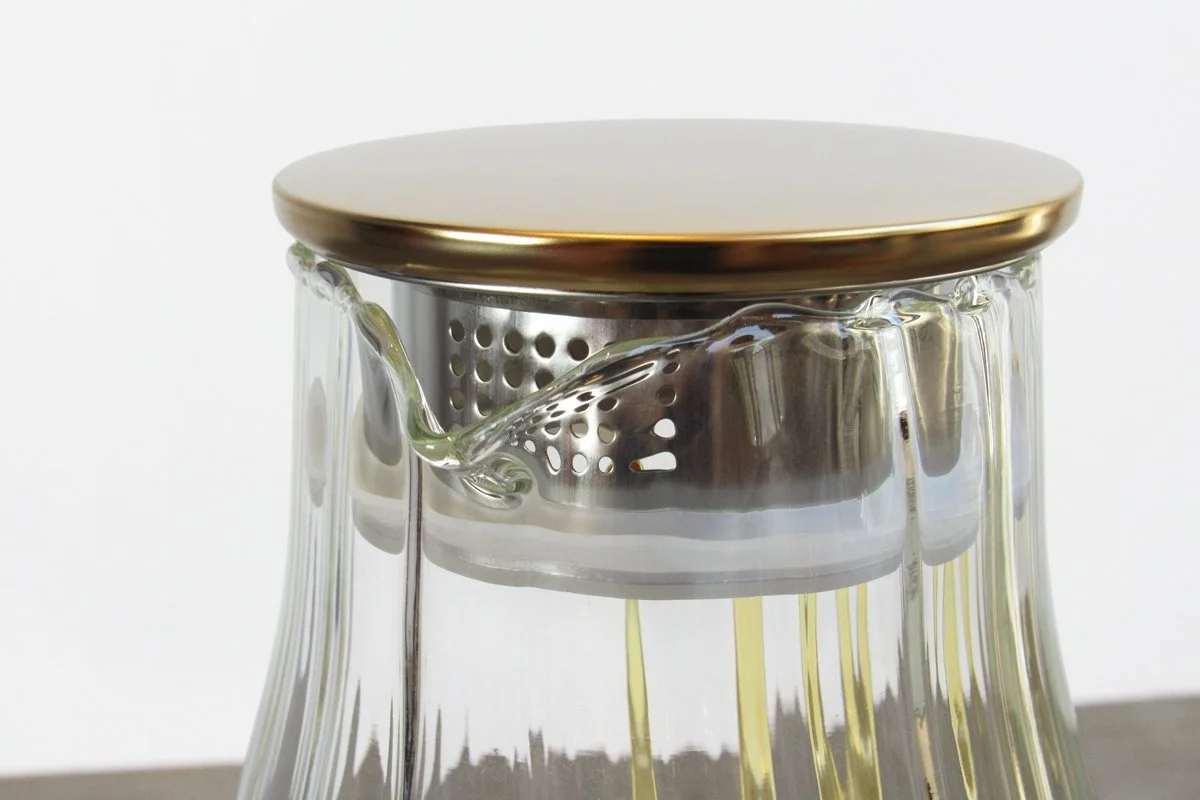 Close-up of the lid of a glass tea pitcher with a built-in tea filter