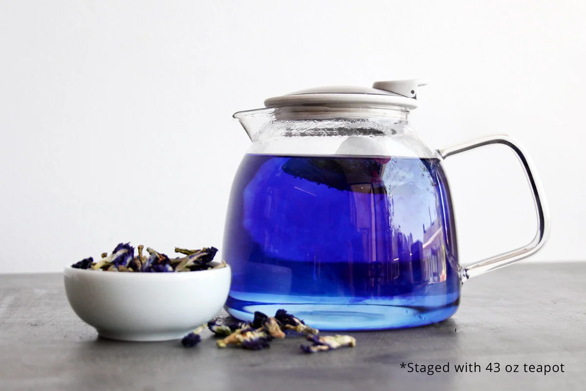 Glass teapot staged with brewed blue butterfly pea tea