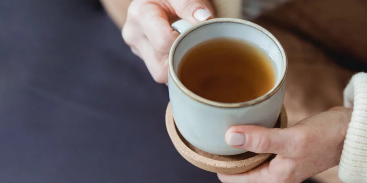 A person holding a cup of immune boosting tea