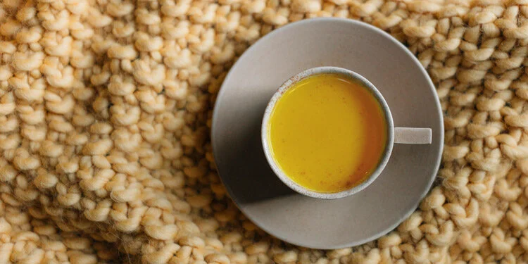 Turmeric latte in a teacup on a plate
