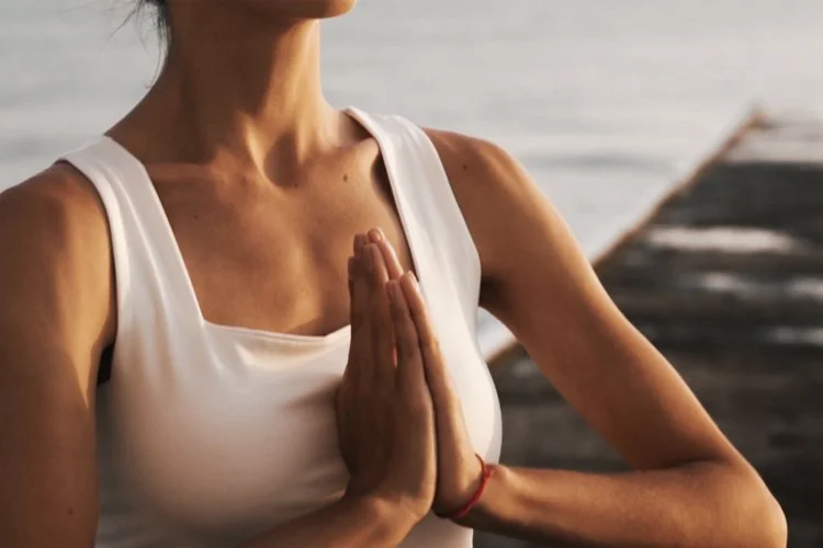 person holding their hands pressed together near their chest in a meditation pose
