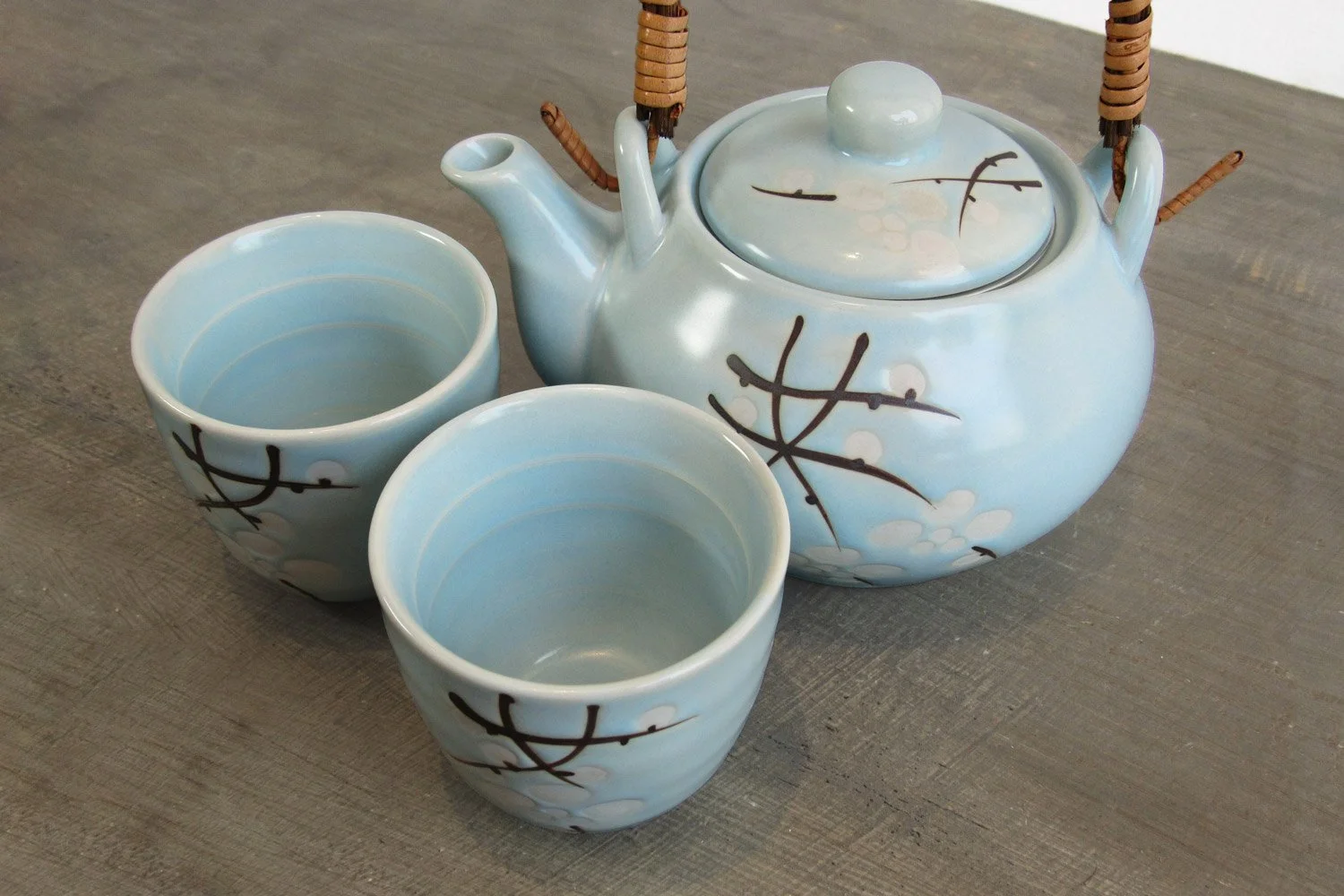 light blue glaze tea set with a design of white blossoms and branches