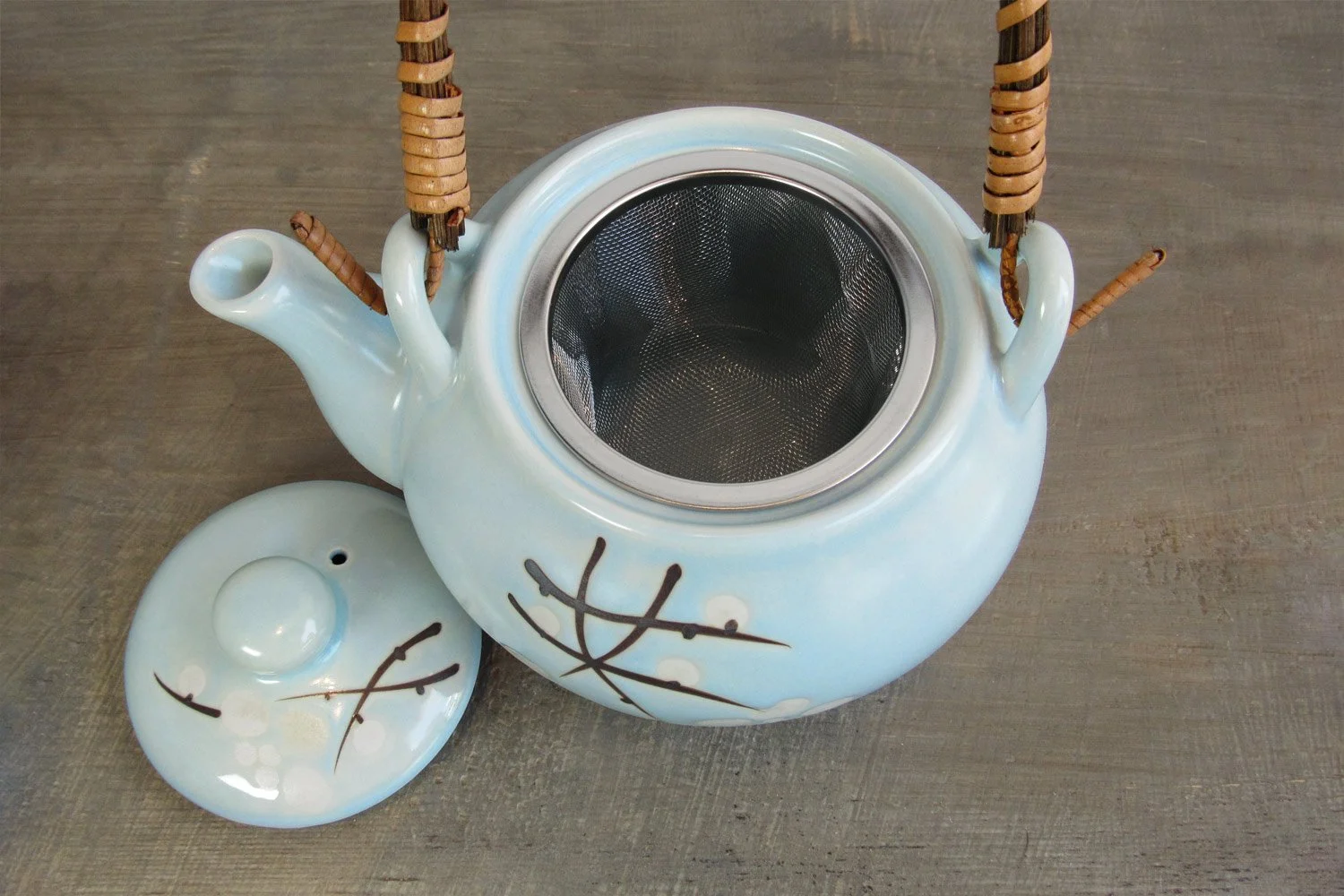 light blue glaze teapot with a removable stainless steel strainer and wrapped rattan handle