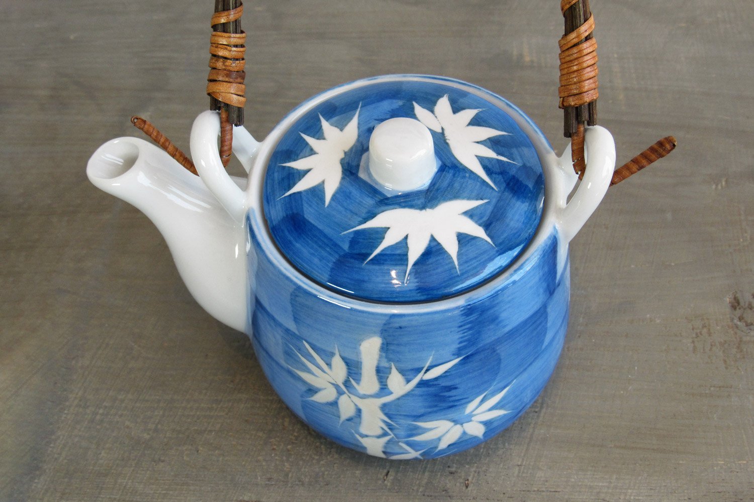 top-down view of a blue teapot with a white bamboo design