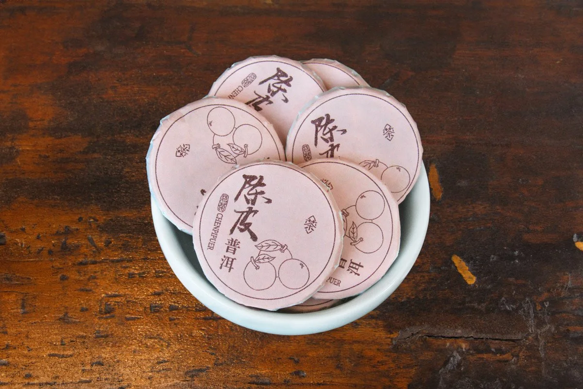 Mini tangerine pu'er tea cakes wrapped in light pink packaging