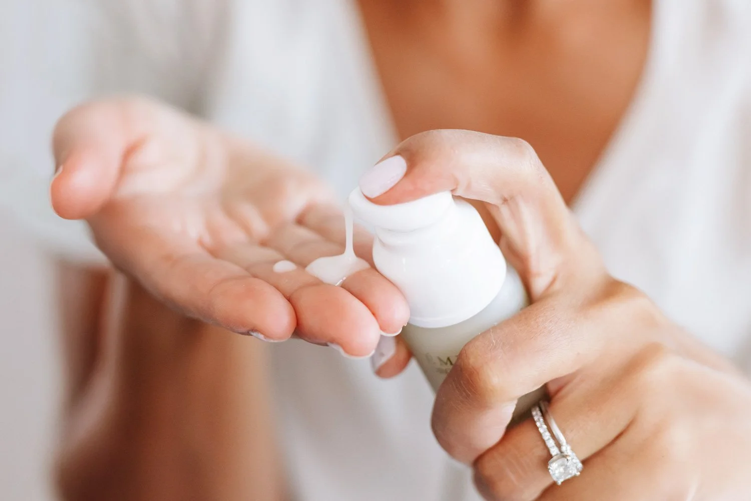 A woman applying Eminence Organics Acne Advanced Clarifying Hydrator on hand