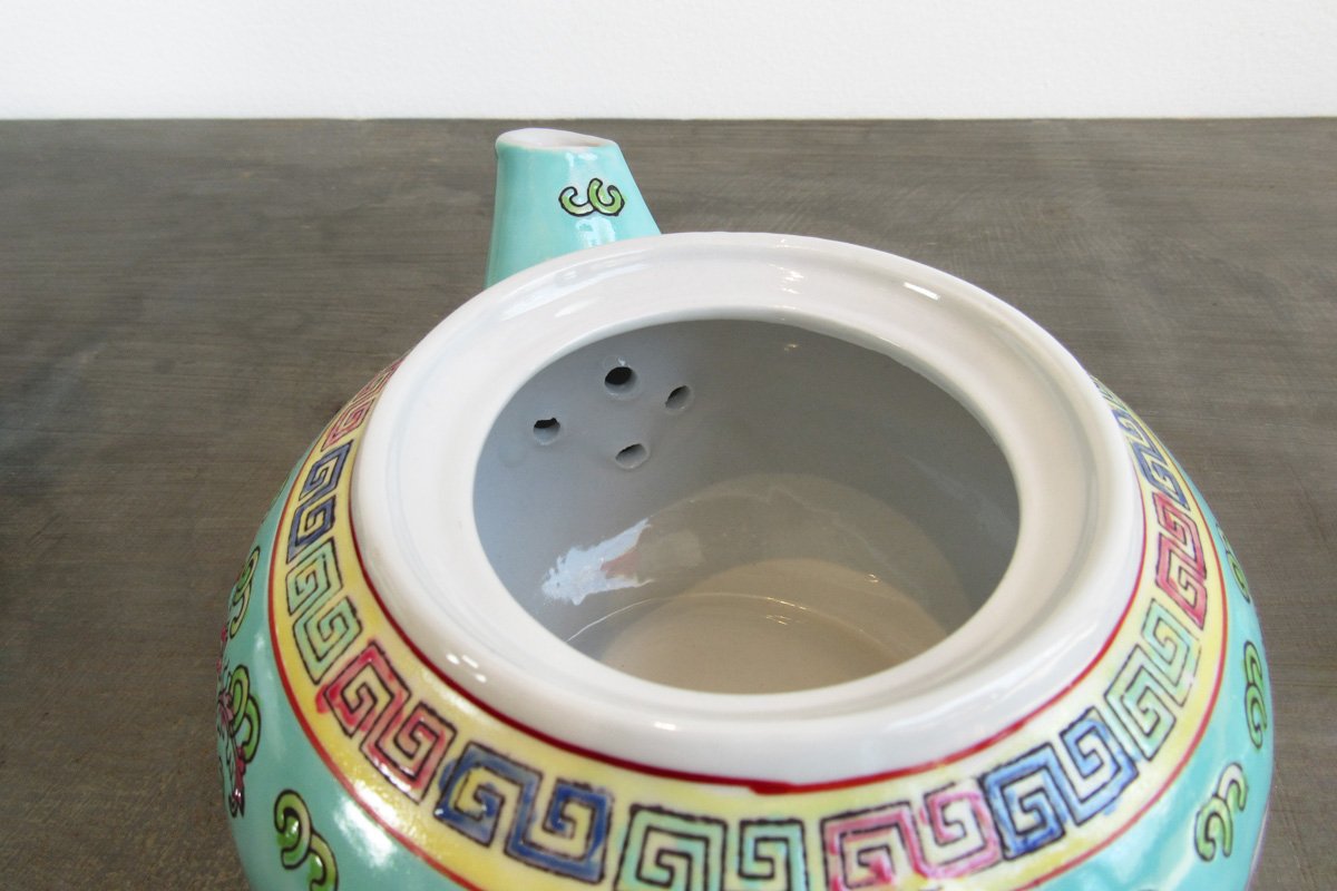 Open teapot showing holes at the bottom of the spout