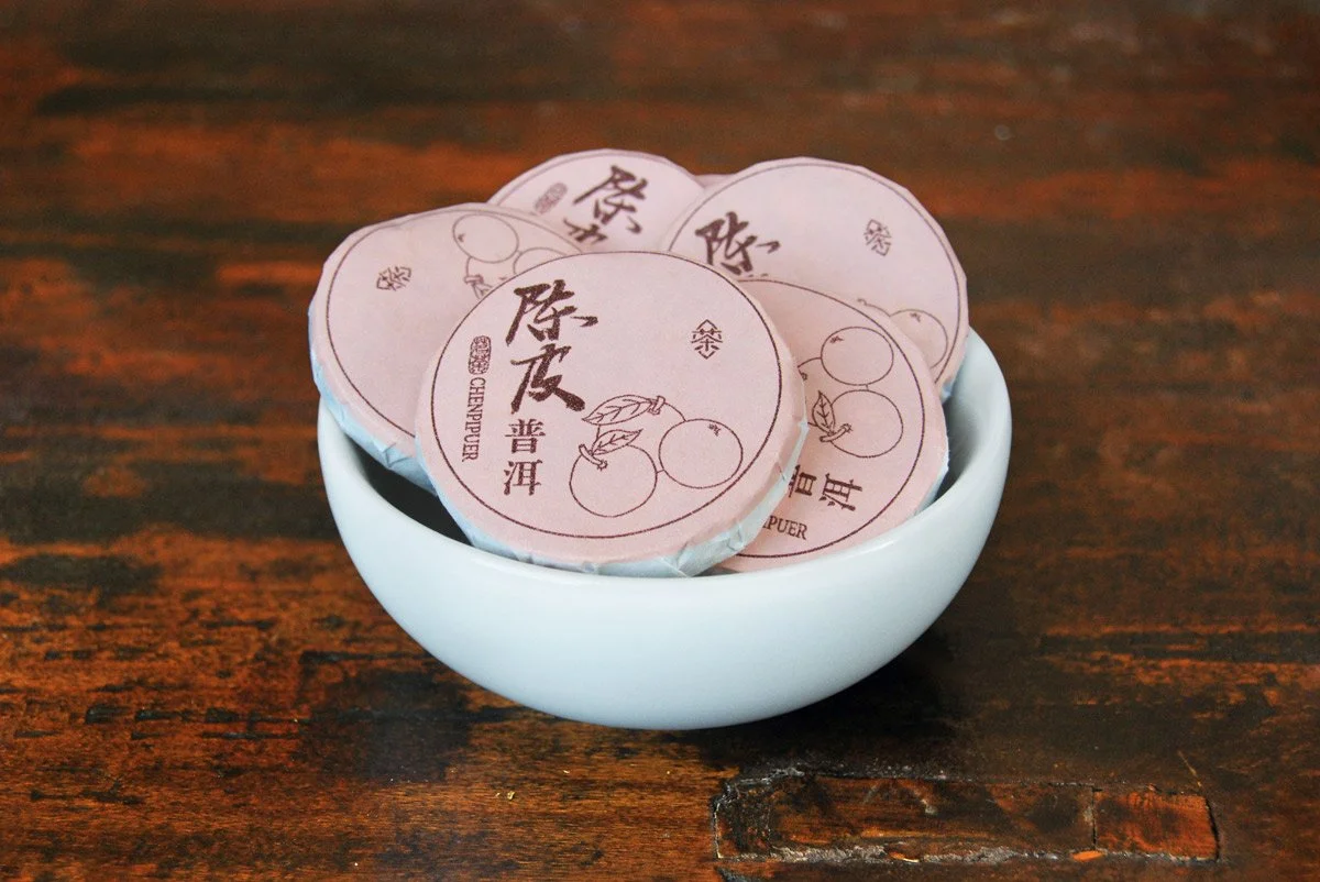 Mini tangerine pu'er tea cakes wrapped in light pink packaging