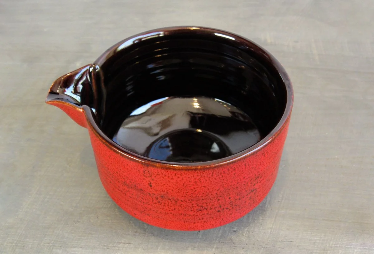 Top view of red spouted matcha bowl with a dark-glazed interior