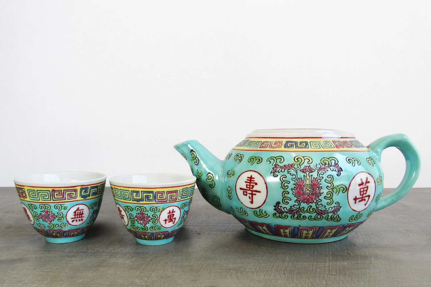 Light turquoise teapot and 2 teacups with hand-painted Chinese characters and botanical patterns