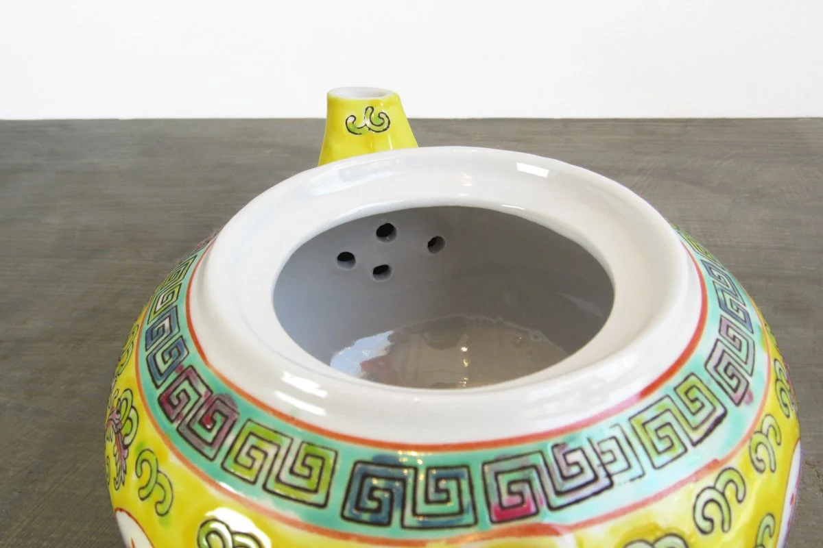 Open teapot showing holes at the bottom of the spout