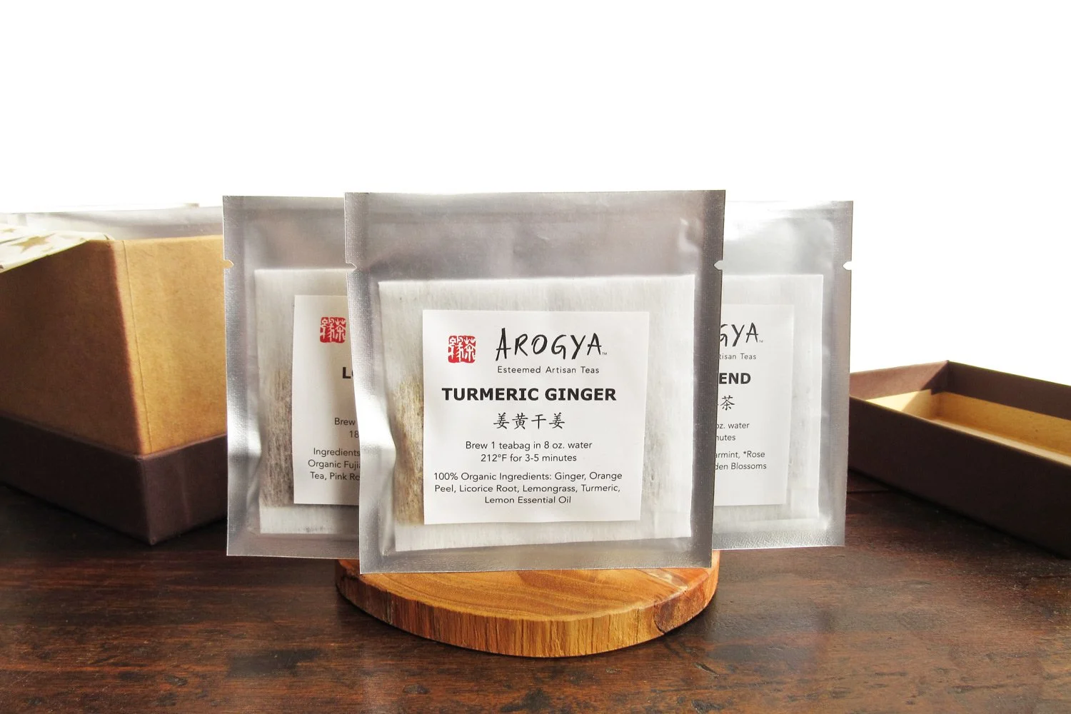 Three packaged teabags displayed in front of the open gift box