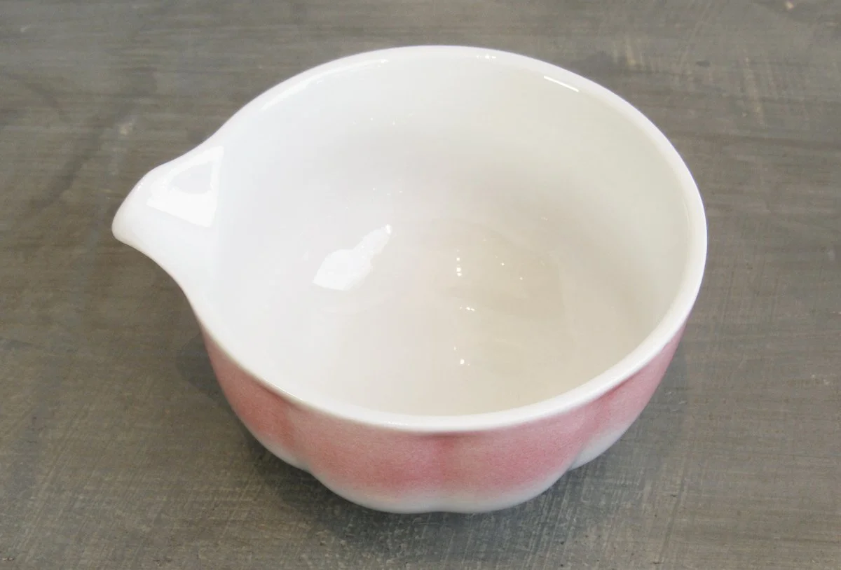 Top view of pink spouted matcha bowl with a white glazed interior