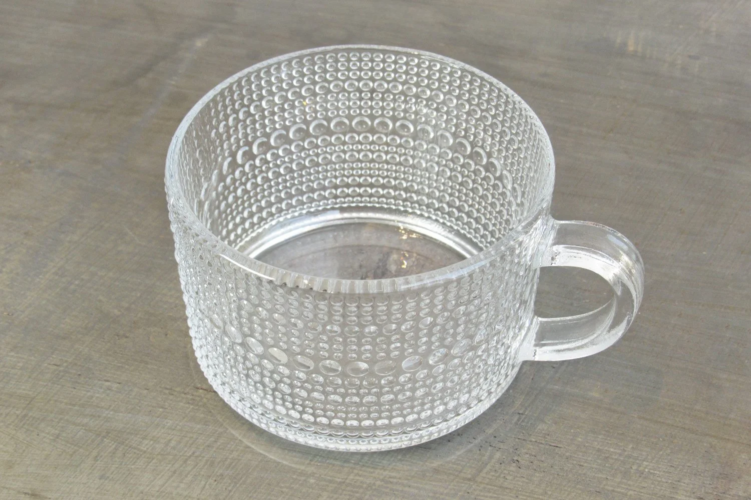 Top-down view of a glass teacup with an embossed hobnail texture