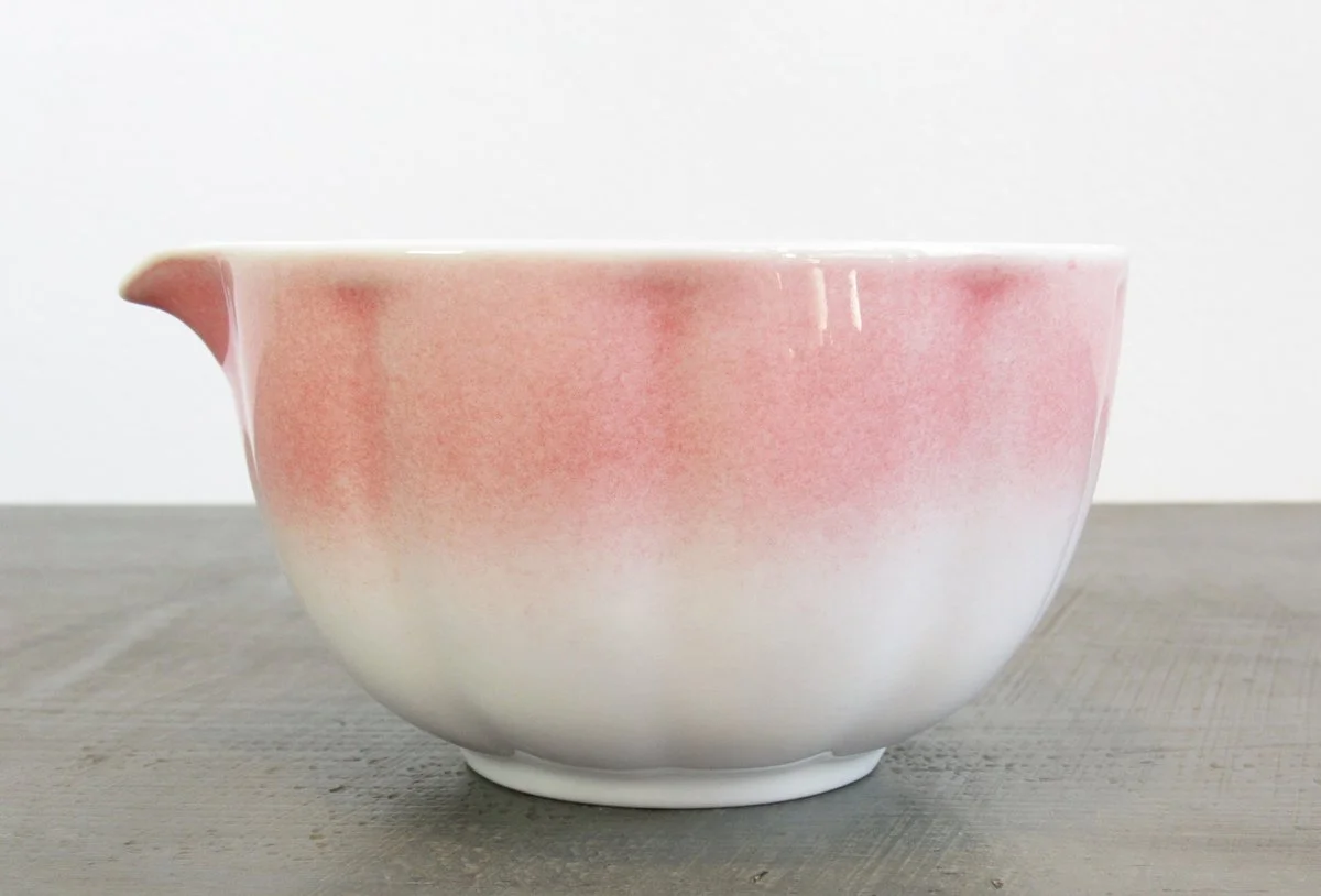 Side view of spouted matcha bowl with a gradient glaze from blush pink to white