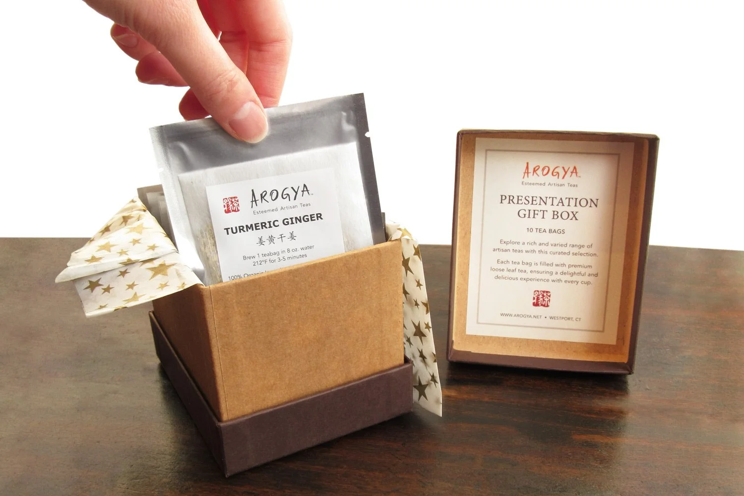 Hand removing a single teabag from the tea gift box