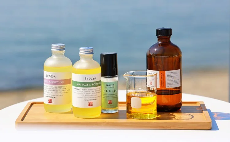 Wooden tray of Arogya massage oils that blend premium essential oils and CBD oil