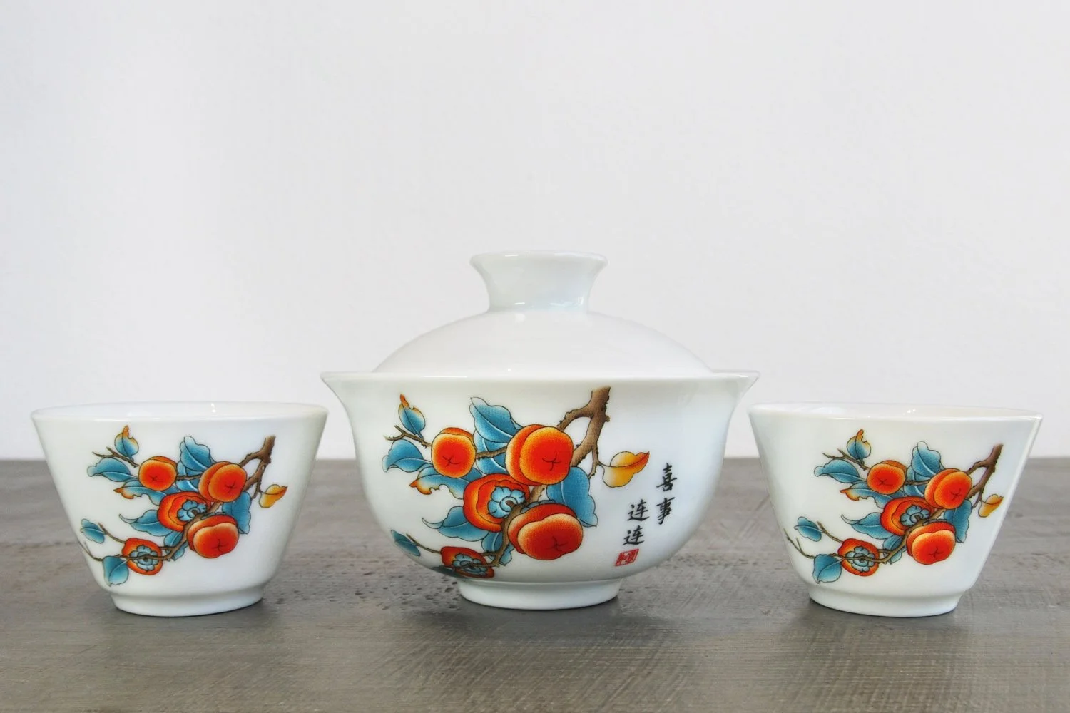 White 3-piece gaiwan set with two teacups decorated with a vibrant persimmon branch design