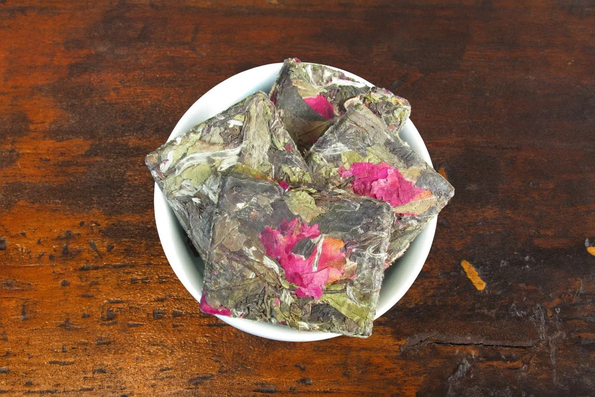 compressed white tea cakes with rose petals in a white bowl