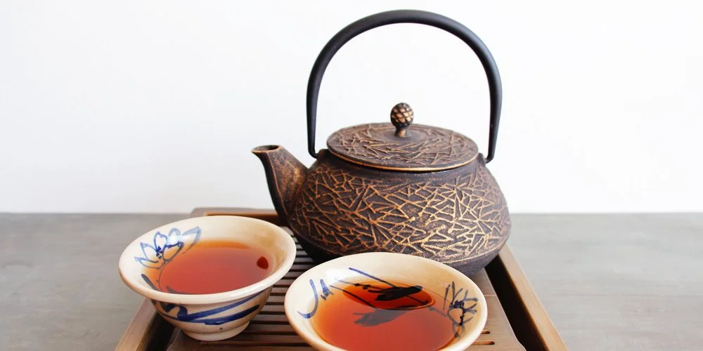 Cast iron teapot and two cups of tea
